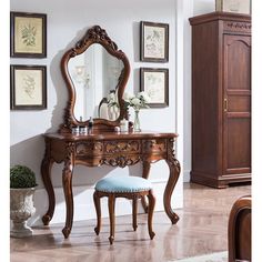 an ornate wooden vanity with mirror and stool in a living room or dining room area