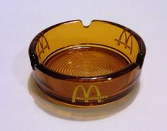 a mcdonald's glass ashtray is shown on a white surface