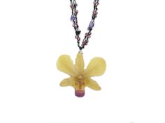 a yellow flower is hanging from a chain