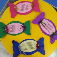 four different colored butterfly shaped plaques on a yellow plate