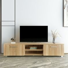 an entertainment center with a flat screen tv mounted on it's side, in front of a white wall