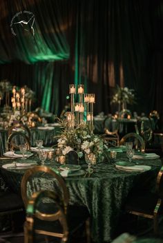 the tables are set up with candles and green tablecloths for an elegant dinner