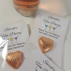 three heart shaped chocolates are sitting on a table next to a glass of wine