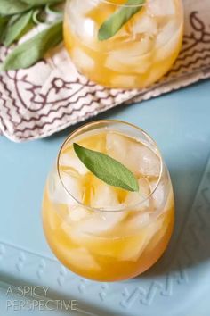 two glasses filled with lemonade on top of a blue tray next to a towel