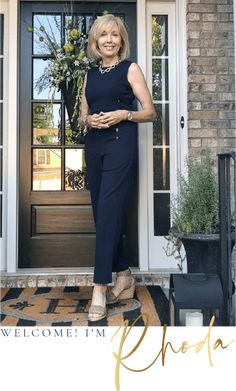 a woman standing in front of a door with her hands on her hips and smiling