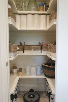 an organized pantry with white shelves and baskets