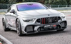 the front end of a silver mercedes amg coupe