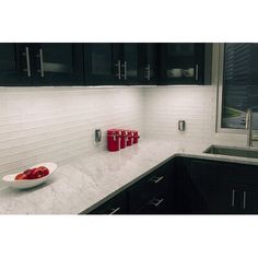 a bowl of fruit sitting on top of a kitchen counter