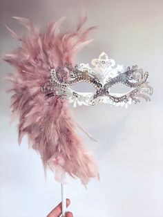 This Beautiful, bold and regal masquerade mask is on a handheld stick and decorated with fine shimmers and crystals and option to embellish with large Feather design. We specialize in customizing masquerade masks to match your event themes and outfit colors. Choose from a variety of masks patterns and we will customize it any color paints, feathers, shimmers and jewels to create an elegant custom masquerade mask for you! Quick processing and expedited shipping available on all orders, let us kno Pink Masquerade Dress, Luxury Masquerade Mask For Festivals And Parties, Elegant Feathered Masquerade Mask For Costume Party, Masquerade Mask Ideas, Pink And Gold Masquerade Mask, Light Pink Masquerade Mask, Masquerade Mask Feathers, Red Mask Masquerade, Pink Masquerade Mask