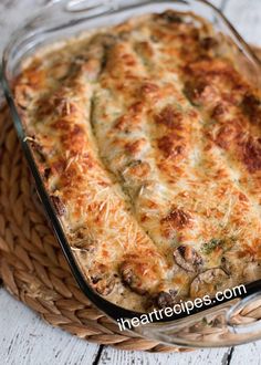 a casserole dish with cheese and mushrooms in it on a wicker basket