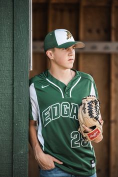 a young man wearing a baseball uniform and holding a catchers mitt