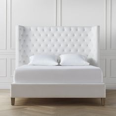 a white bed with two pillows on it