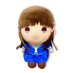 a stuffed animal doll with brown hair and blue dress sitting on top of a white surface