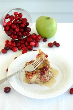 a white plate topped with dessert next to an apple and cranberry toppings