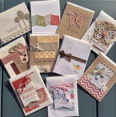 many different types of greeting cards on a wooden surface with ribbons and tags attached to them