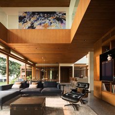 a living room with couches, chairs and a flat screen tv on the wall