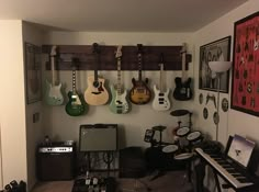 a room with guitars and musical equipment hanging on the wall