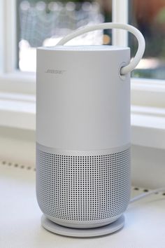 an echo speaker sitting on top of a window sill next to a white wall