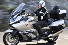 a man riding on the back of a silver motorcycle