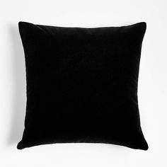 a black pillow sitting on top of a white wall