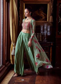 Editor's Note Featuring a bustier adorned with thread-work and sequins. The palazzo pants and cape are hand painted and printed alluringly with floral motifs Fabric: Bustier: viscose silk, cape: viscose georgette, pants: cotton silk Color: Green Components: Buster, cape and pants Occasion: Festive and Wedding Guest Disclaimer: Product color may slightly vary due to photographic lighting sources or your monitor setting. Care: Dry Clean Only About the Designer Kalista is a luxury fashion label tha Churidar Sleeves, Lehenga Anarkali, Embroidered Bustier, Green Cape, Silk Cape, Partywear Dresses, Set Saree, Traditional Indian Outfits, Palazzo Set