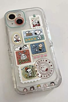 an iphone case with many stickers on the front and back of it, sitting on top of a white surface