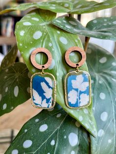 Introducing our exquisite handmade earrings, a perfect blend of creativity and nature-inspired design. Each pair is meticulously crafted with a unique cyanotype technique, showcasing the beauty of natural elements. These earrings feature unique hand-printed cyanotypes encased in resin and complemented with wood fixtures. Nature-inspired Dangle Earrings, Nature-inspired Dangle Flower Earrings, Handmade Nature-inspired Flower Earrings, Nature-inspired Blue Dangle Earrings, Turquoise Nature-inspired Drop Earrings, Blue Nature-inspired Drop Earrings, Handmade Botanical Drop Earrings, Bohemian Pressed Flowers Drop Earrings, Unique Pressed Flowers Earrings