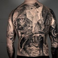 a man with tattoos on his back is holding an umbrella