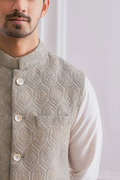 Ash grey Nehru jacket in pure georgette base fabric featuring delicate thread and sequins embroidery. Component: 1 Pattern: Embroidered Type Of Work: Thread and Sequins Neckline: Mandarin Sleeve Type: Sleeveless Fabric: Pure Georgette; Lining: Twill Satin Color: Grey Other Details:  Front button down jacket Pocketed jacket Note: The kurta and churidar worn by the model is not for sale Occasion: Wedding - Aza Fashions Mens Koti Kurta, Kurta Koti For Men, Nehru Jacket For Men Wedding Classy, Kurta With Nehru Jacket For Men, Kurta Jackets For Men, Koti Jacket For Men, Koti Kurta For Men Wedding, Kurta With Jacket For Men, Nehru Jacket For Men Wedding