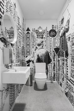 a bathroom with black and white artwork on the walls