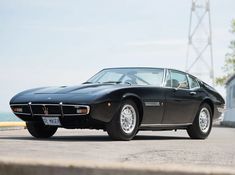 an old black sports car parked on the street