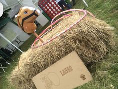 an inflatable horse head sitting on top of hay next to a cardboard sign