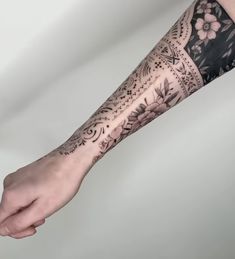 a person's arm with tattoos on it and flowers in the middle of their arm