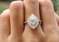 a woman's hand with a ring on it that has an oval shaped diamond in the center