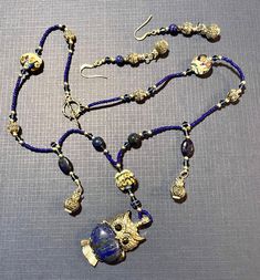 introducing "Owl Song" a sterling silver and lapis lazuli necklace complemented by luxurious and sparkling Swarovski crystals and etched hand crafted sterling rounds. Sterling owl bells, hang delicately from the necklace, adding a tinkling affect with your every movement. The lovely lampwork beads add a bit of intrigue. Owl's dark crystal eyes, add an allure of wisdom and stealth. Add a sense of mystery to your attire with this captivating necklace and earring set which can be worn casually or to a gala event. Wherever you choose to wear it, it is sure to be a conversation starter and add a little mystery to your life. Luxury Sapphire Jewelry In Lapis Lazuli, Elegant Royal Blue Beaded Jewelry, Beaded Lapis Lazuli Pendant Jewelry, Lapis Lazuli Beaded Pendant Jewelry, Artisan Silver Lapis Lazuli Jewelry, Lapis Lazuli Gemstone Beads Pendant Jewelry, Silver Lapis Lazuli Jewelry With Polished Beads, Artisan Lapis Lazuli Gemstone Beads Jewelry, Sapphire Lapis Lazuli Jewelry For Jewelry Making