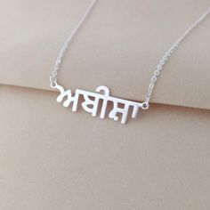 Personalized Punjabi name necklace is the perfect gift for your dearest person. The minimalist design makes it elegant, and the personalization with the unique design really upgrades your personal charm, catching others' eyes. Or personalize this Punjabi necklace with the name of your beloved or an Inspiring word, it adds a unique appearance to the person you care about. Your purchase will arrive inside a lovely gift box ready for gift giving. How to order: 1, Select color and chain length. 2, P Silver Pendant Name Necklace For Gifts, Silver Necklace With Simple Design As Gift, Silver Necklace With Simple Design For Gift, Spiritual Style Name Necklace Gift, Traditional Personalized Necklace, Spiritual Name Necklace As A Gift, Spiritual Name Necklace For Gift, Silver Name Necklace For Mother's Day, Spiritual Silver Name Necklace For Mother's Day