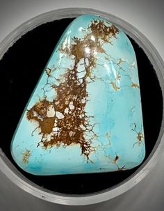 a piece of turquoise and brown stone sitting on top of a table