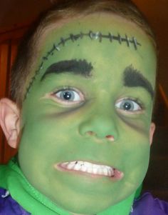 a young boy with his face painted green