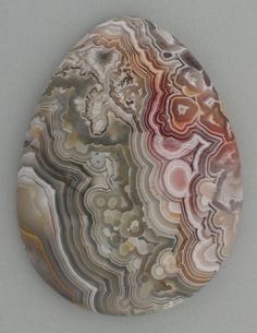 a piece of art that looks like an egg with different colors and shapes on it