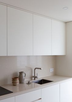 a kitchen with white cabinets and a sink