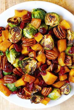 a white plate topped with brussel sprouts and sweet potatoes