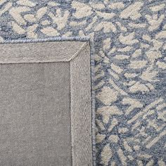 a blue and white rug with a square frame on the bottom right corner, next to it's border