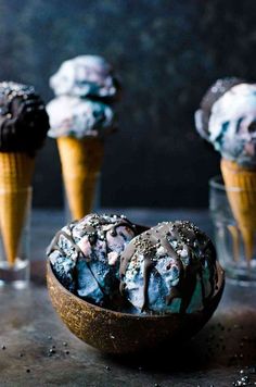 three scoops of ice cream with chocolate sprinkles in them on a table