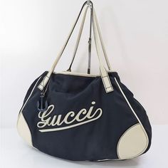 Pre Loved Authentic Gucci Navy Nylon And Off-White Leather Tote Bag Purse. This Is One Of My All Time Favorites And So Rare. Lettering Does Have Cracks In It But Nothing A Cobbler Can’t Fix. Please See All Pictures And Ask Any Questions. Made In Italy Approximate Size W 16.5 (Bottom) H 11.4 D 3.9 Handle Drop 9.1 Elegant Shoulder Bag With Embroidered Logo For Travel, Gucci Designer Bag With Embroidered Logo, Designer Gucci Bag With Embroidered Logo, Black Gucci Shoulder Bag With Logo, Designer White Bag With Embroidered Logo, Tote Bag Purse, Cobbler, Leather Tote Bag, White Leather