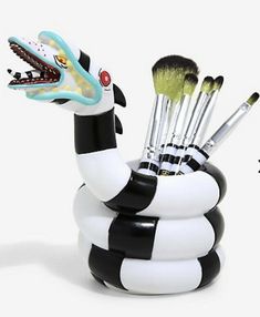 a black and white snake toothbrush holder with brushes in it