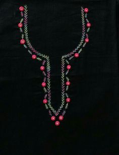 a black shirt with pink beads and green leaves on the front, hanging from it's chest