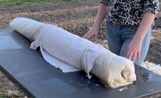 a woman standing next to a large piece of food