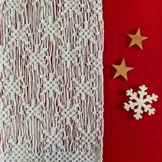 two wooden snowflakes sitting next to each other on a red tablecloth with white crochet