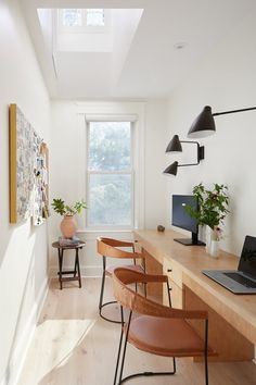 a long desk with chairs and a laptop on it