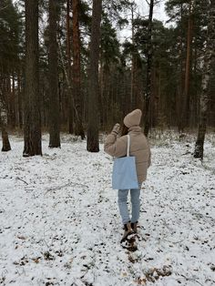 a person standing in the snow near some trees